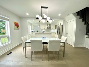 Enjoy meals in the kitchen with a central island and dining area featuring a table and chairs.