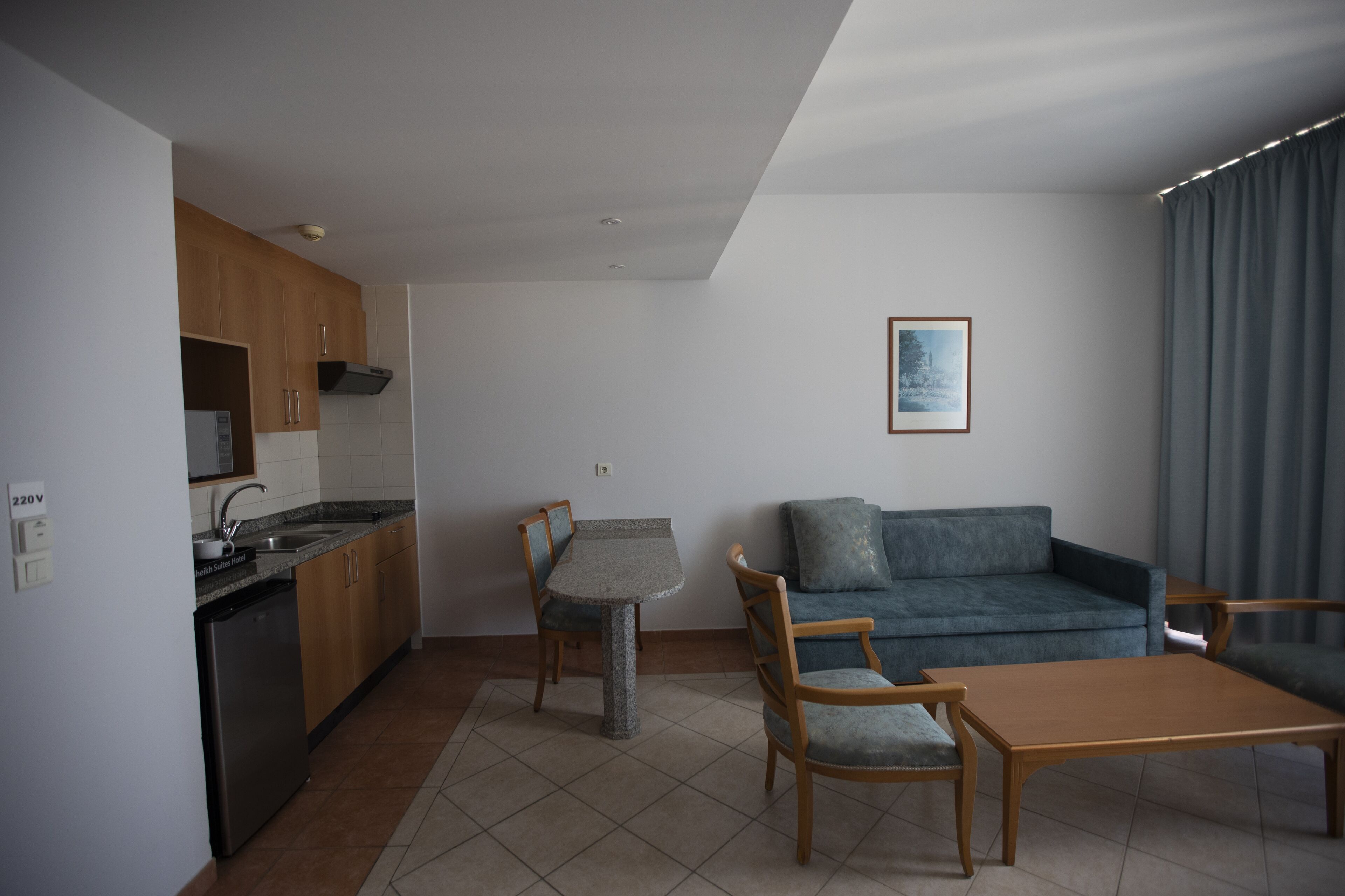 A compact living space with a kitchenette, a dining table, a sofa, and a coffee table.
