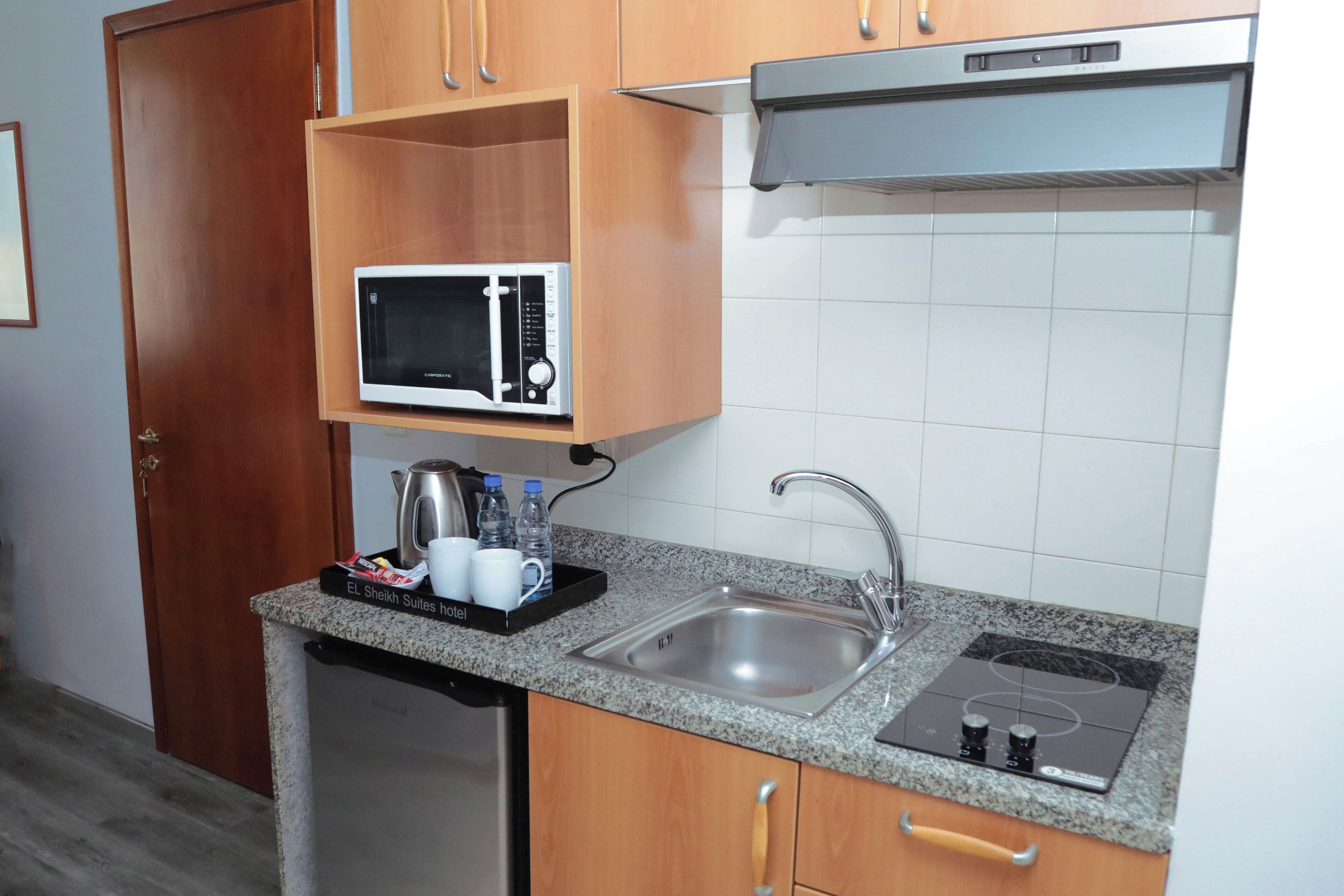 A compact kitchen with a built-in microwave, a sink, and a stove.