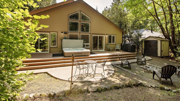 Una casa con jacuzzi, mobiliario exterior y un patio cubierto.