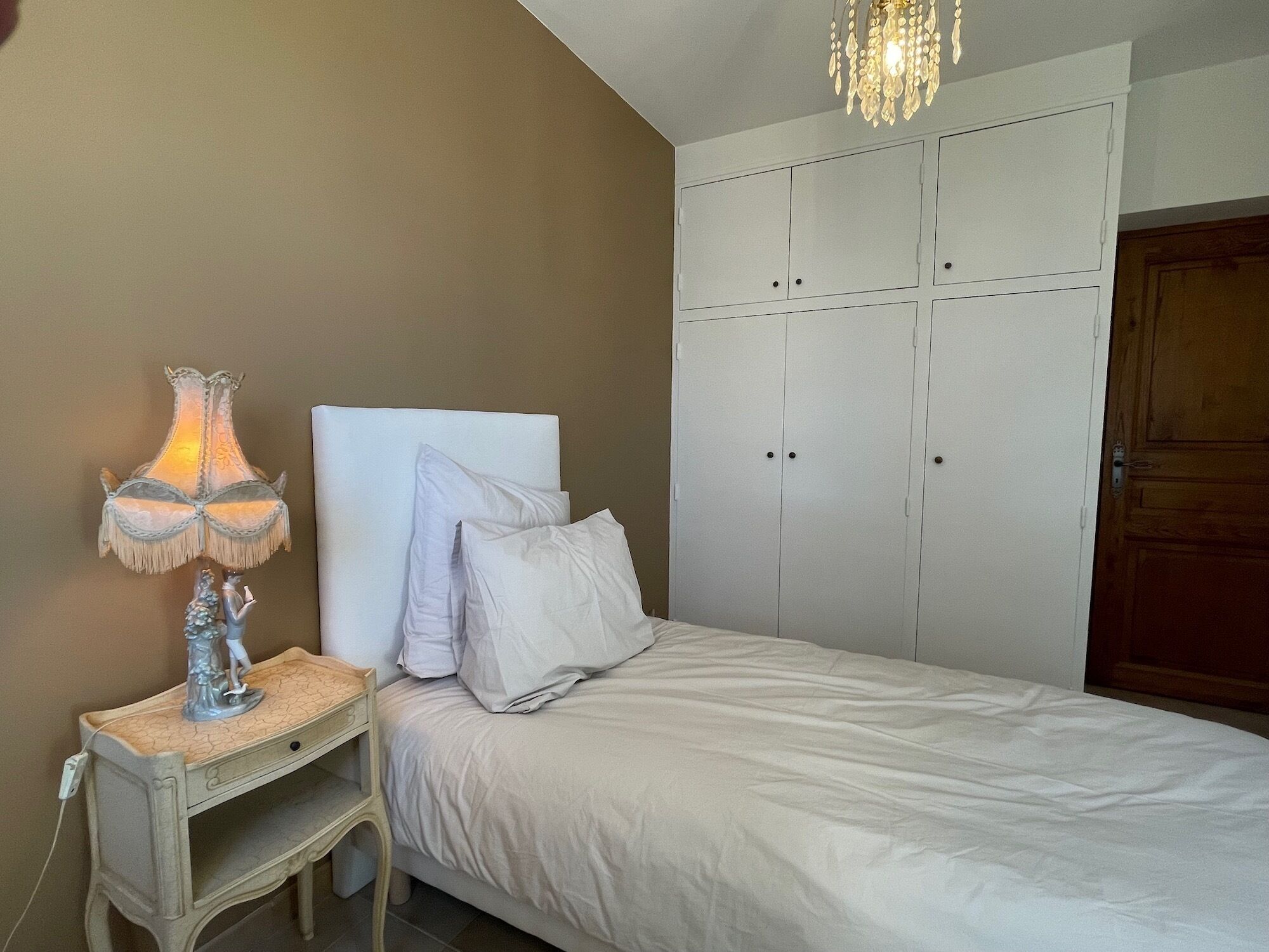 Ein Schlafzimmer mit einem Bett, einem Nachttisch mit Lampe und einem Kleiderschrank.
