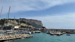 A marina with boats docked, a rocky cliff in the background, and a clear sky. - Villa Grand Cédre - Family house with infinity pool, garden 4000m2. (Marseille)