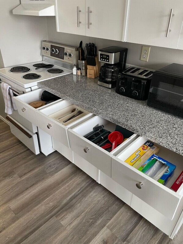 Cocina equipada con estufa integrada, cafetera y tostadora. Hay varios cajones para almacenamiento.