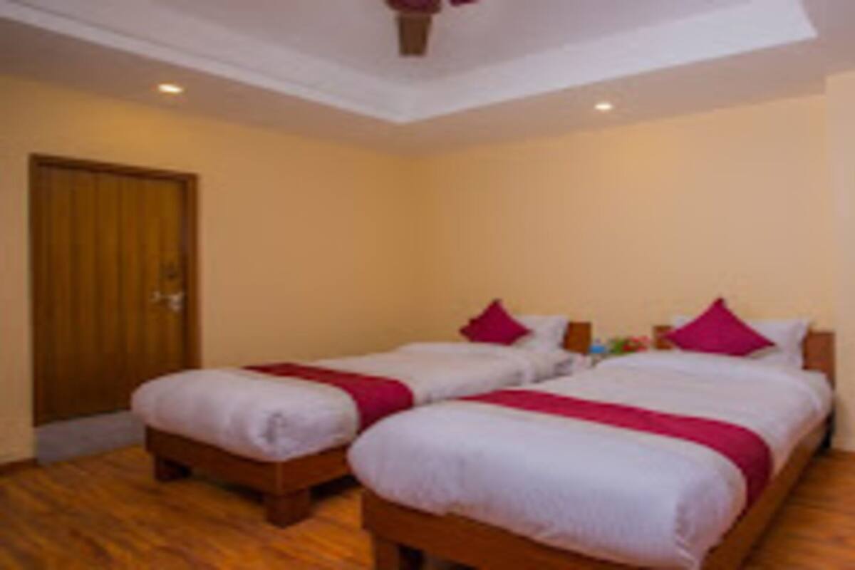 Un dormitorio con dos camas individuales, un escritorio de madera y una silla.