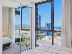 Enjoy a panoramic city view from the balcony, featuring a comfortable bed and minimalist interior design.