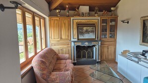 A cozy living room with a fireplace, wooden cabinets, and a sofa. - Executive Huge Flat in Central Lugano (Lugano)