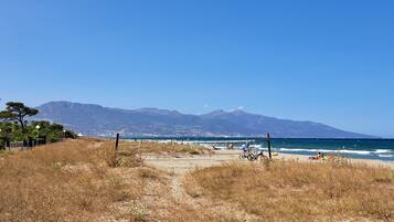 Ranta lähistöllä, aurinkotuoleja, rantapyyhkeitä