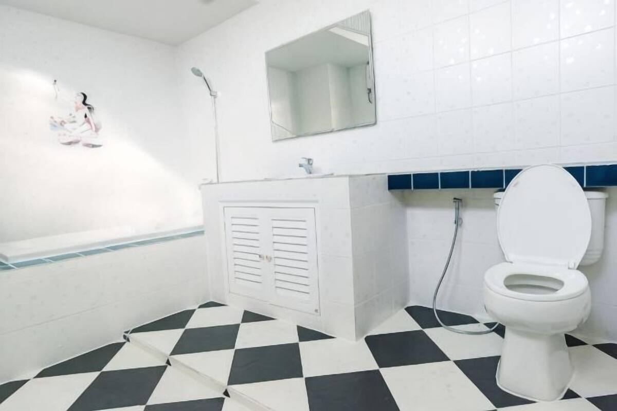 A bathroom with a white bathtub, a white toilet, and a shower.