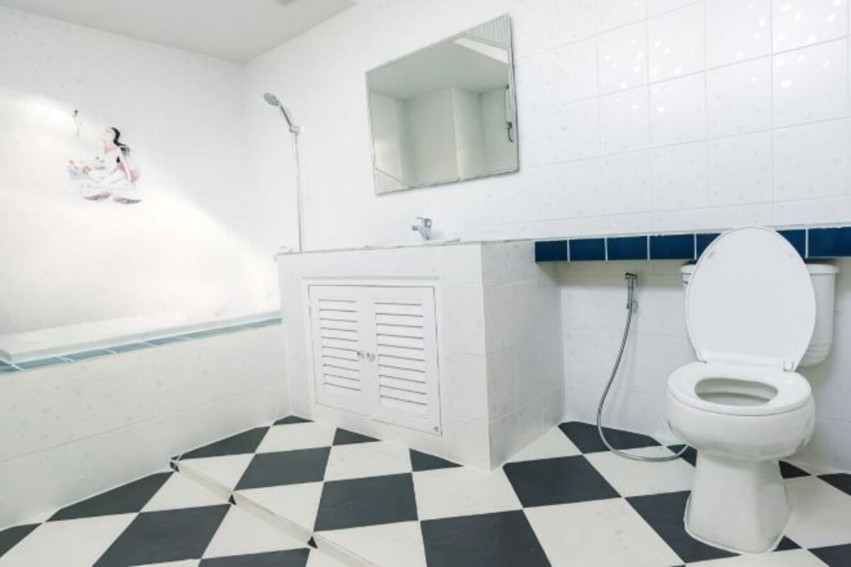 A bathroom with a white bathtub, a white toilet, and a shower.