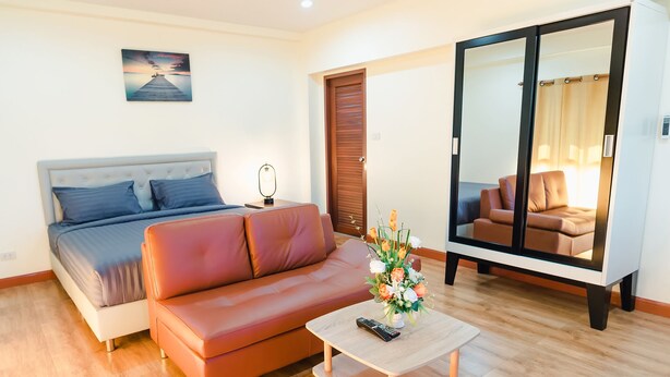 Ein Schlafzimmer mit Bett, Schlafsofa, Couchtisch und Kleiderschrank.