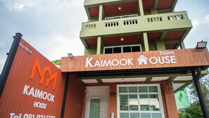 Ein Gebäude mit einem Schild, auf dem „Kaimook House“ und eine Telefonnummer stehen.