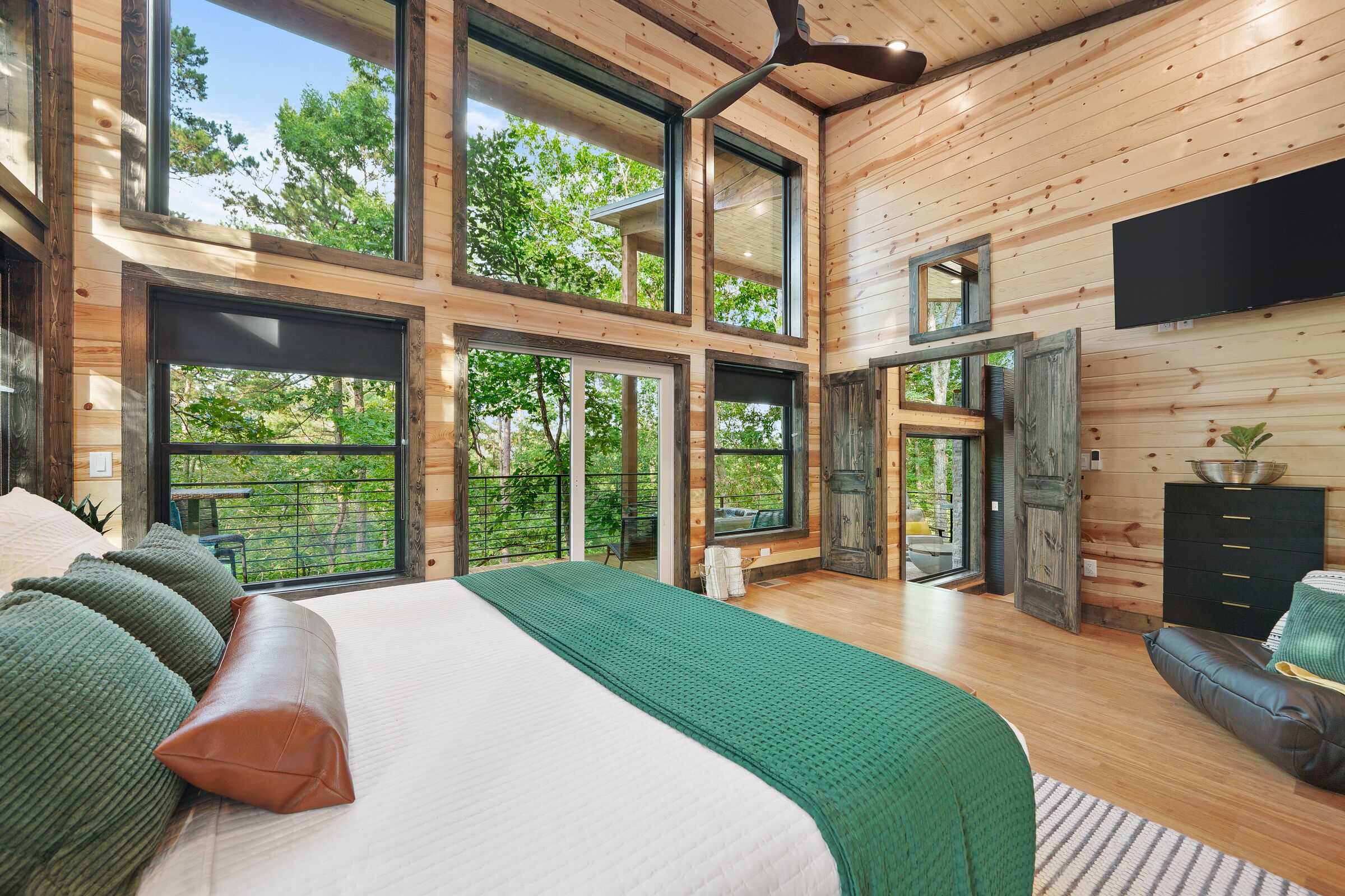 Une chambre spacieuse avec un grand lit, de nombreuses fenêtres et une vue sur l’extérieur.