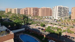 Un hotel di grandi dimensioni con numerosi balconi, una piscina e un'area parcheggio.