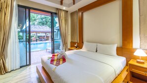 Une chambre d’hôtel avec un grand lit, une table de chevet, une lampe et une vue sur l’espace extérieur abritant une piscine.