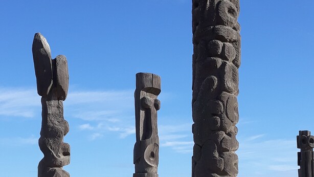 A beach with stone sculptures and a clear blue sky.