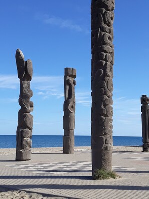 A beach with stone sculptures and a clear blue sky.