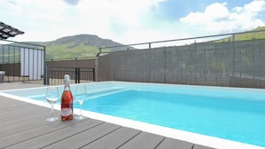A swimming pool with a wooden deck, a bottle of wine, and two wine glasses. - YalaRent Villa lumièra with Private Pool (Migdal)