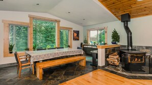 A spacious room with a large wooden table, benches, and a fireplace. - Prosser Paradise_Hot Tub, Arcade, Walk 2 Prosser Reservoir, Exercise Equip, Kid Toys & Air Purifiers (Truckee)