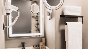 A bathroom with a large mirror, a sink, a towel rack, and a hairdryer. - Persona Hotel Galata (Istanbul)