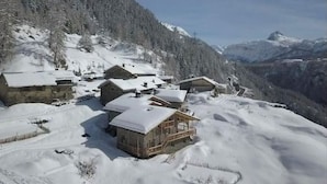 A snow-covered mountain village with wooden houses and a clear view of the surrounding mountains. - Chalet au Sud, Face aux Glaciers (Tignes)