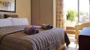Ett hotellrum med en säng, ett skrivbord och utsikt över omgivningarna.