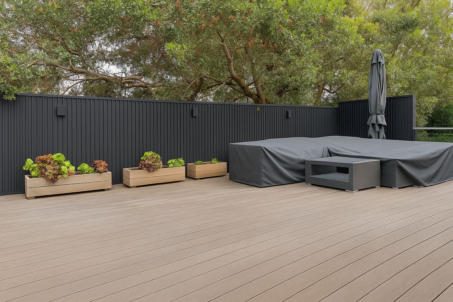 An outdoor seating area with a covered table and chairs, surrounded by planters with greenery.