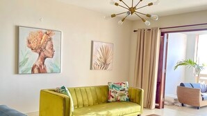 A living room with a yellow sofa, a blue sofa, a wooden coffee table, and a ceiling fan.