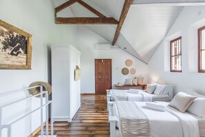 A bedroom with two beds, a wooden ceiling, a white wardrobe, and a door. - We Escape (Weligama)