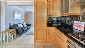 Una cocina moderna con armarios de madera, estufa a gas y cafetera.