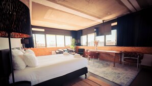 Un hotel moderno con una cama grande, un escritorio y vistas a la ciudad.