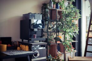 A compact living space with a television, a coffee machine, and a small dining table. - YOUNG Learning Hotel (Rijswijk)