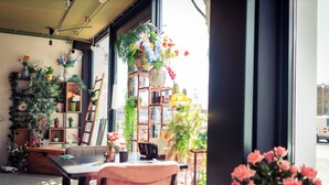 Una habitación con una mesa, sillas y una ventana que da a la calle.