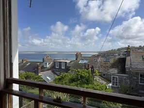 Une ville côtière avec des maisons à étages, une vue sur la mer et un ciel dégagé.