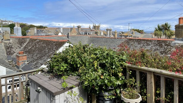 A rooftop garden with potted plants and a wooden railing. - Treholme - a cottage that sleeps 6 guests in 3 bedrooms (St Ives)