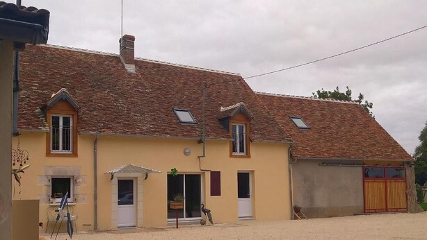 A two-story building with a tiled roof, a small balcony, and a covered entrance. - Gîte de la Basse Roche (Souge)