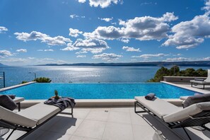A infinity pool with a view of the sea and mountains.