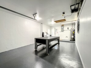 Um corredor com mesa de pingue-pongue, paredes brancas e piso lustroso.