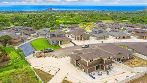 Un quartier résidentiel avec des maisons, une allée et une vue sur l’océan.