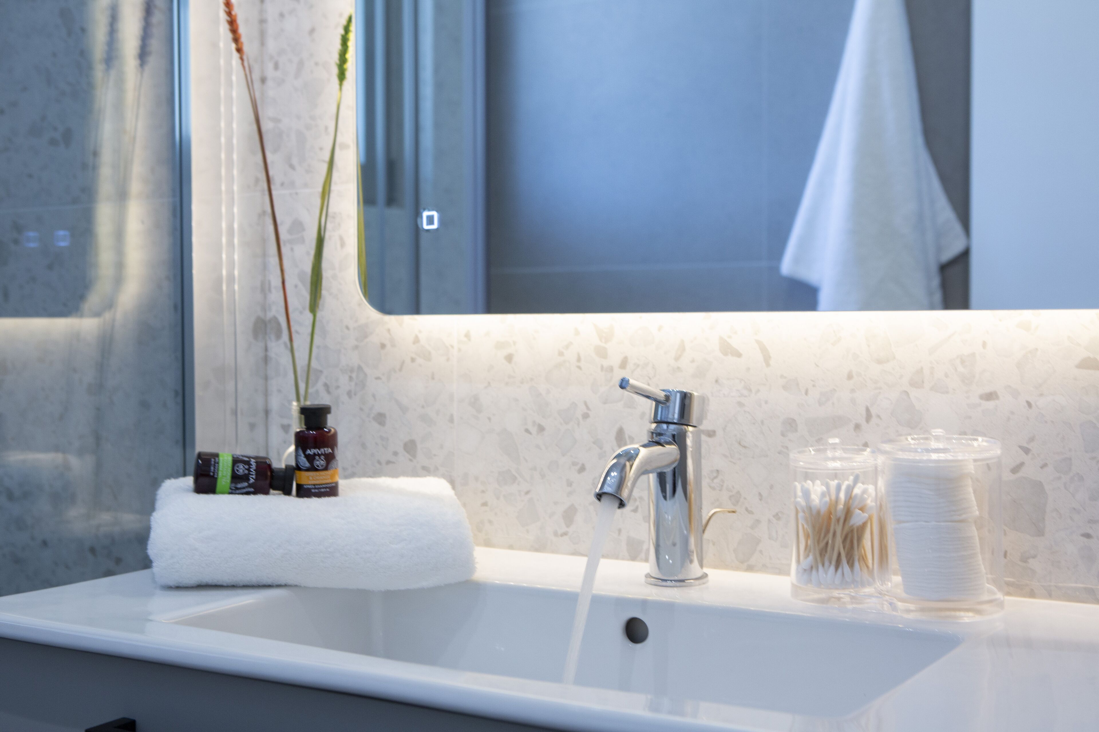 Un lavabo de salle de bain avec un miroir, une serviette et des articles de toilette.