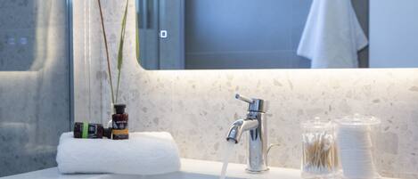 Un lavabo de salle de bain avec un miroir, une serviette et des articles de toilette.