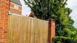 A wooden gate with a metal latch, brick wall, and a house number 140. - Modern Room with Private Outdoor space - Pass the Keys (Newcastle)