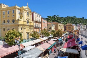 A bustling street with colorful buildings and outdoor market stalls. - Studio Neuf au Cœur du Carré Dor, rue Dalpozzo, 5 Minutes des Plages (NICE)