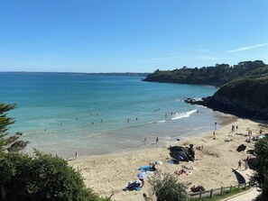 A beach with clear blue water, sandy shore, and rocky cliffs. - Maison Familiale Proche mer (Plestin-les-Grèves)