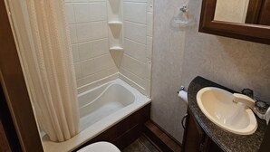 Un baño pequeño con ducha, inodoro y lavabo.