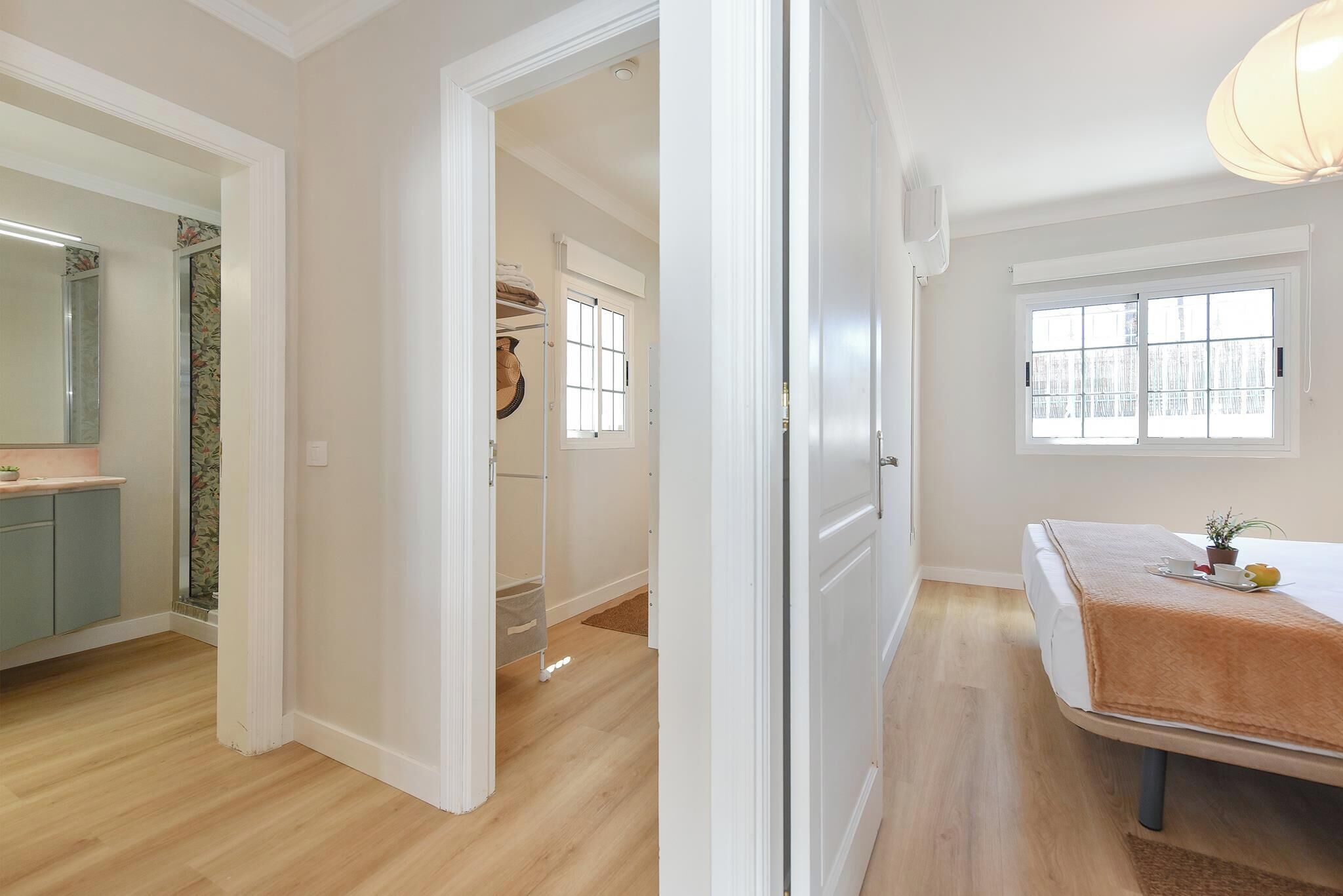 A modern bedroom with a large bed, a bedside table, and a window with a view.