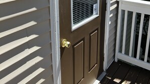 A brown front door with a window and a white doorbell. - Cozy 3BR Beach House by the Sea (Old Orchard Beach)
