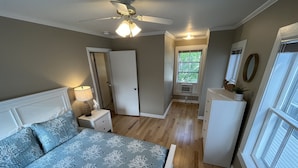 A bedroom with a bed, nightstand, dresser, ceiling fan, and a window. - Cozy 3BR Beach House by the Sea (Old Orchard Beach)