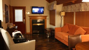 A living room with a fireplace, a television mounted above it, and a sofa.