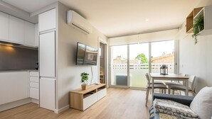 Un appartement moderne doté d’une cuisine, d’un coin repas et d’un balcon avec vue.