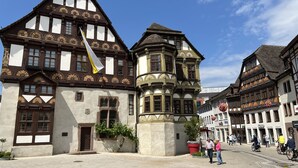 A historic building with traditional architecture, featuring a prominent tower and a large flag. - Marketplace apartment (Höxter)